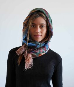Fular de lana Hidra Knit llevado al cuello y sobre la cabeza
